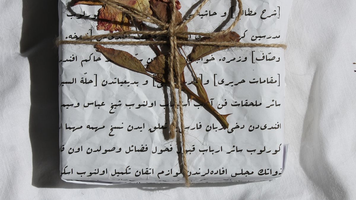 A paper-wrapped gift tied with twine and a dried flower